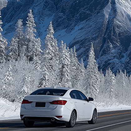 White sedan driving through snow covered mountain canyon White sedan driving through snow covered mountain canyon