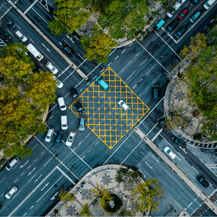 Aerial view of a busy city intersection surrounded by trees. Aerial view of a busy city intersection surrounded by trees.