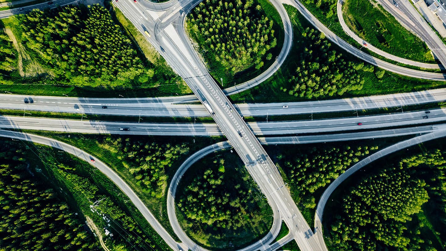 aerial-view-of-highway-and-overpass-with-green-woo-2025-04-01-21-11-33-utc-16-9 aerial-view-of-highway-and-overpass-with-green-woo-2025-04-01-21-11-33-utc-16-9