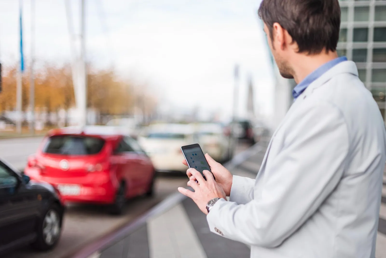 Person holding a phone waiting for a car Person holding a phone waiting for a car